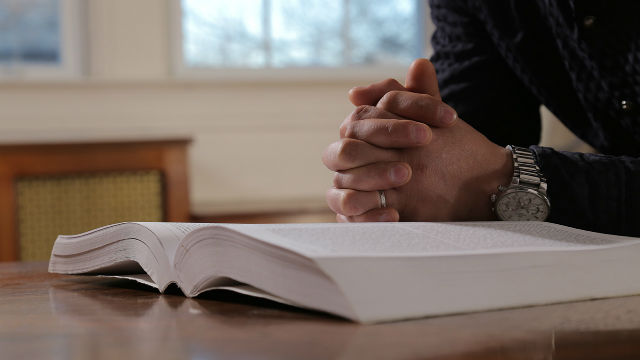 基督徒在聖經旁禱告尋求天國奧秘